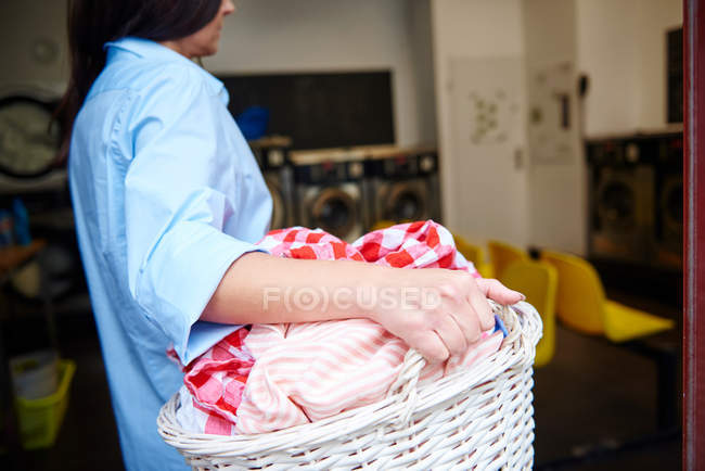 Mulher carregando cesta de roupa — Fotografia de Stock