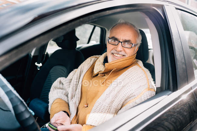 Hombre sentado en el coche - foto de stock
