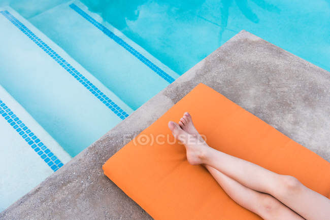 Niño acostado en la piscina - foto de stock