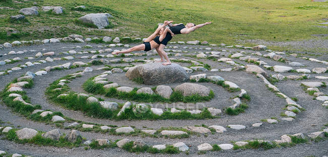 Acrobats performing on stone arrangement — Stock Photo