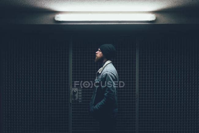 Hipster in dark city doorway at night — Stock Photo