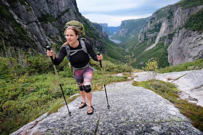Woman hiking up rocky valley — Stock Photo