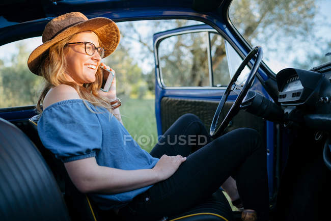 Женщина в машине с помощью смартфона — стоковое фото