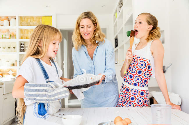 Mother and daughters baking in kitchen — Stock Photo