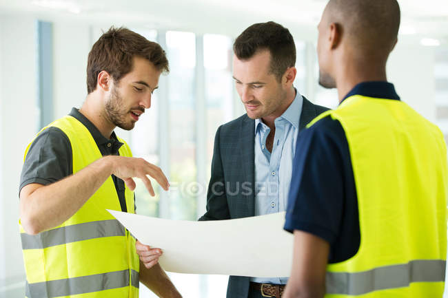 Construction workers and businessman — Stock Photo