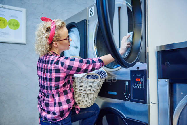 Mulher removendo a roupa do secador de roupa — Fotografia de Stock