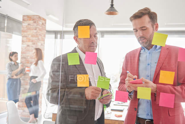 Colleagues brainstorming using sticky notes — Stock Photo