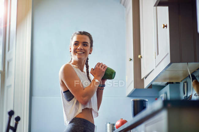 Young woman shaking juicer — Stock Photo