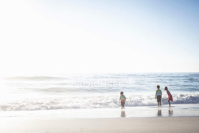 Братья и сестры на пляже — стоковое фото