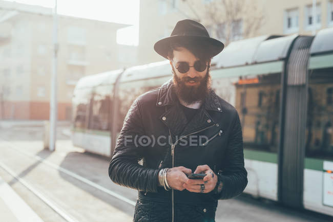 Hipster regardant smartphone — Photo de stock