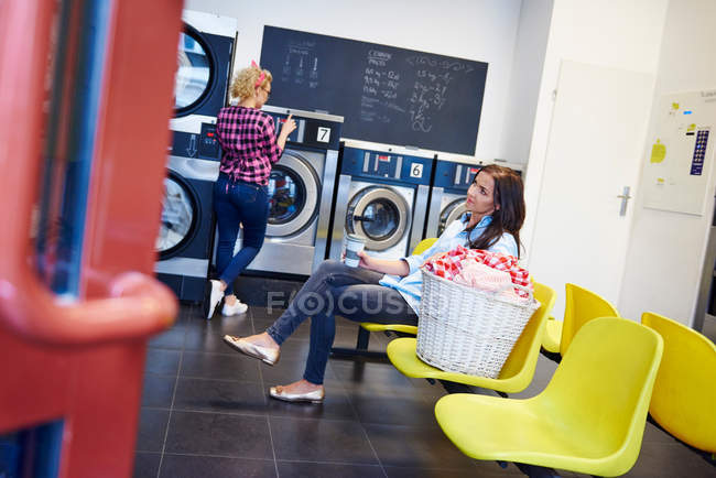 Woman waiting in laundrette — Stock Photo