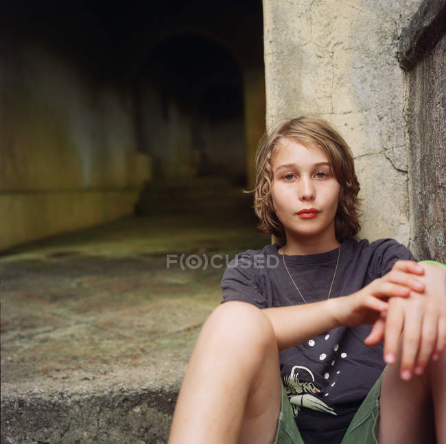 Boy, sitting in urban setting — Stock Photo