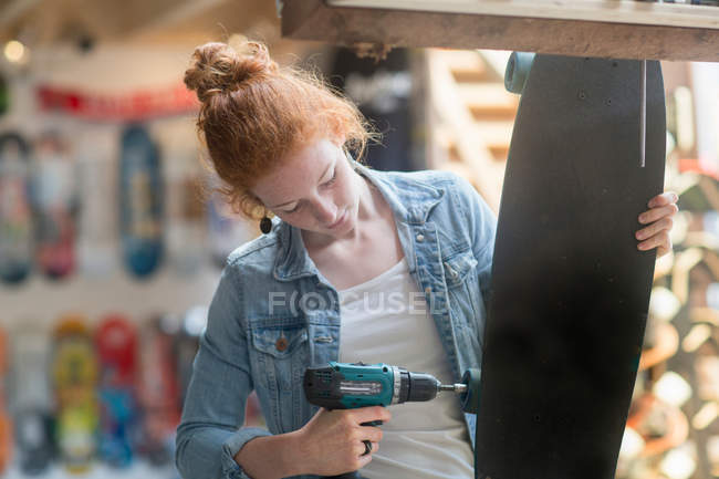 Donna che lavora nel negozio di skateboard — Foto stock