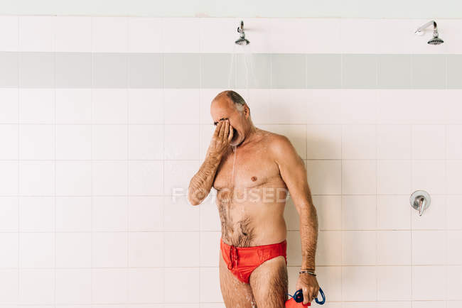 Homme utilisant douche de piscine — Photo de stock