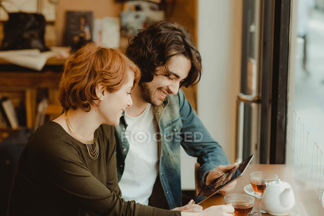 Молодая пара сидит в кафе — стоковое фото