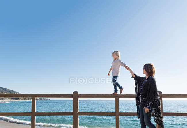 Молодий хлопчик ходить уздовж паркану — стокове фото