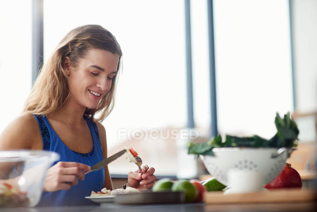 Молодая женщина за кухонным столом — стоковое фото