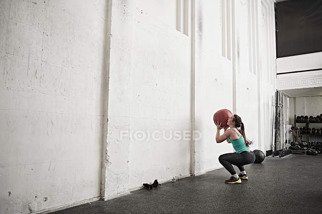 Frau wirft Fitnessball — Stockfoto
