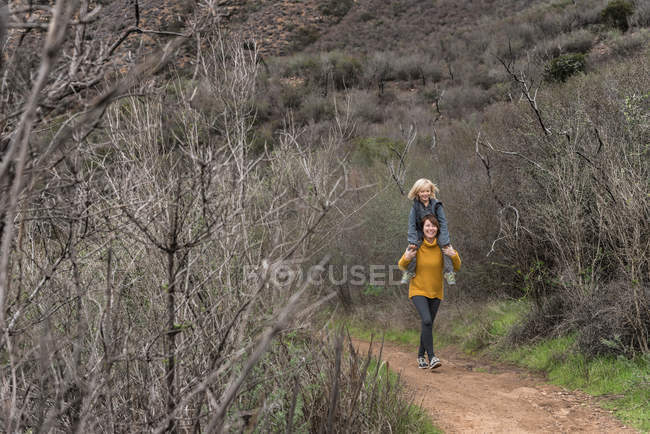 Женщина, идущая по сельской дороге — стоковое фото