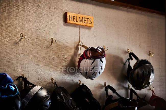 Ski helmets on coat hooks — Stock Photo