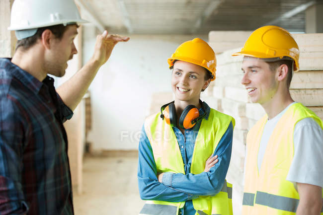Three people standing in constructions site — Stock Photo