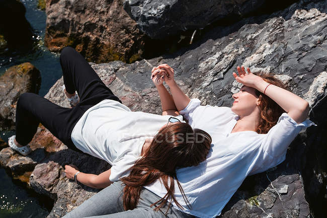 Mejores amigos relajándose en rocas - foto de stock