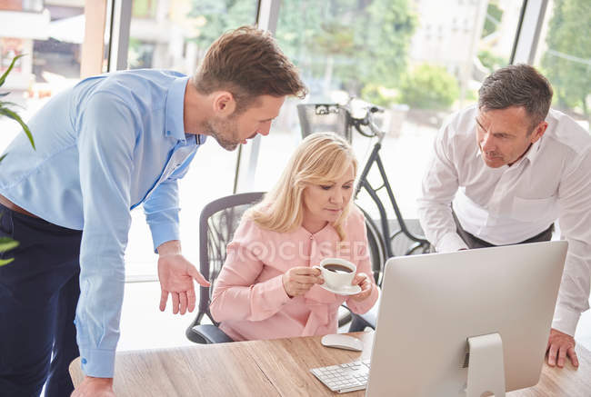Colleagues in office with computer — Stock Photo