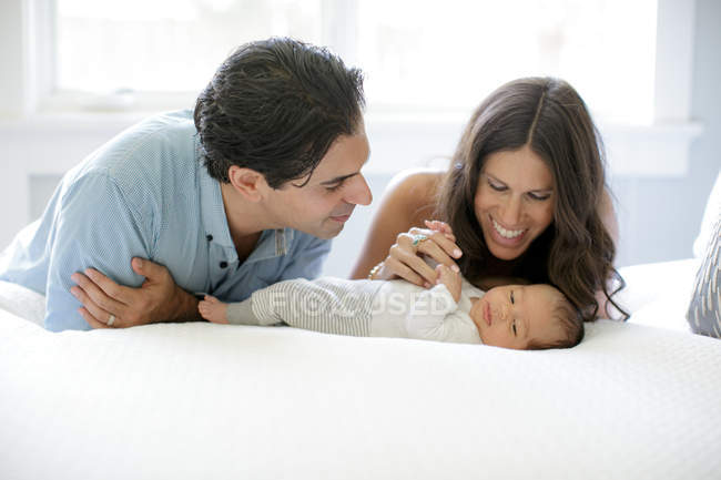Padre y madre mirando al recién nacido - foto de stock