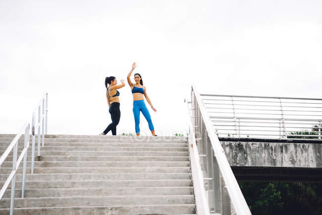 Two young women at top of steps — Stock Photo