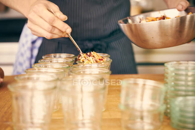 Chef filling plastic containers — Stock Photo