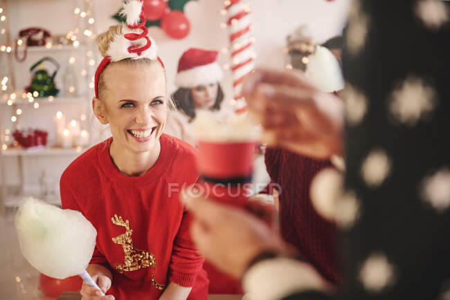 Jovem mulher e homem com doces e pipocas na festa de Natal — Fotografia de Stock