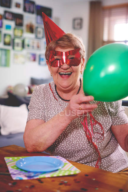 Seniorin schwenkt Luftballon — Stockfoto