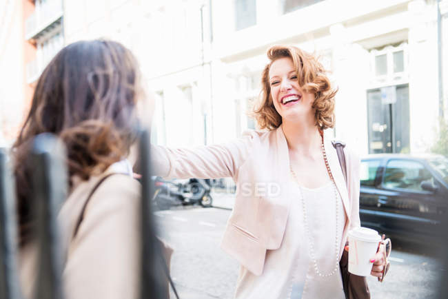 Two women laughing at street — Stock Photo