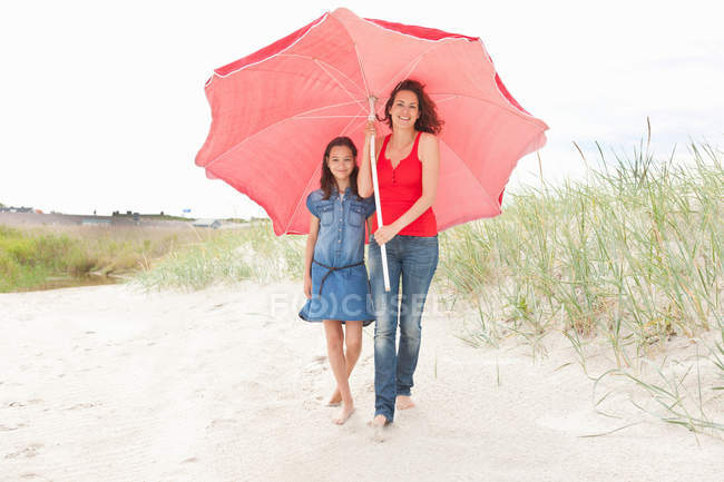 Mère et fille portant un parapluie — Photo de stock