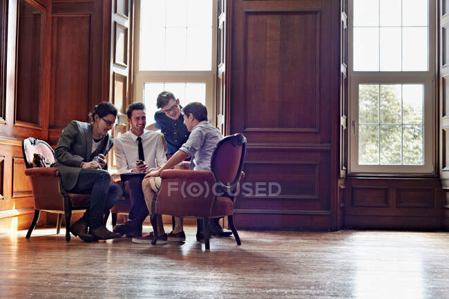 Les hommes d'affaires parlent dans une pièce ornée — Photo de stock