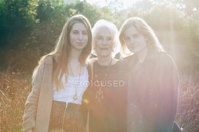 Großmutter umarmt Enkelinnen — Stockfoto