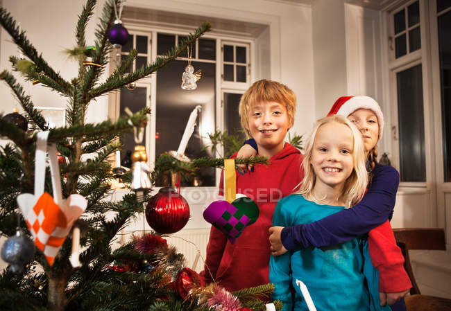 Children smiling near Christmas tree — Stock Photo