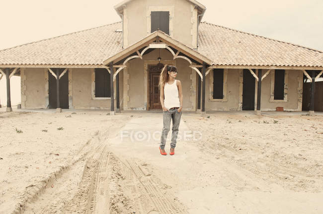 Женщина стоит перед заброшенным зданием — стоковое фото