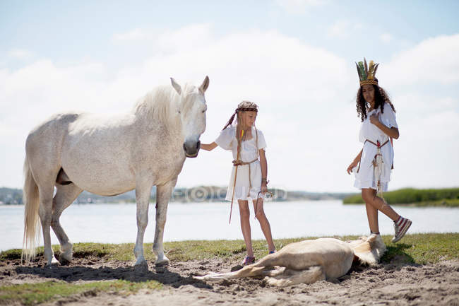 Chicas con caballos en la playa de arena - foto de stock