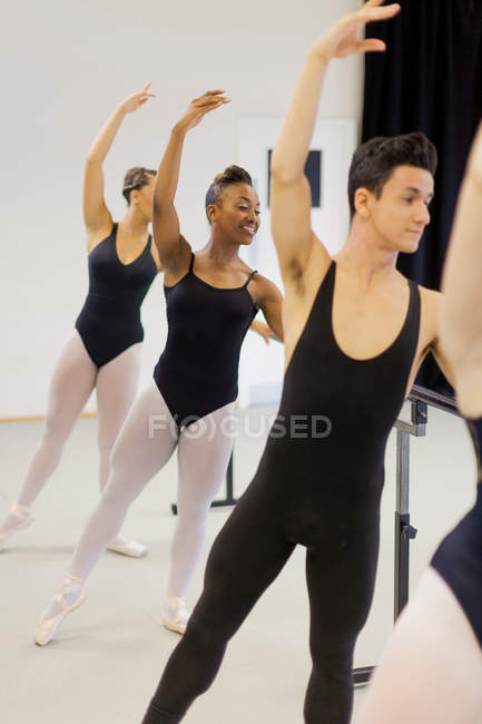 Ballet dancers practicing at barre — Stock Photo