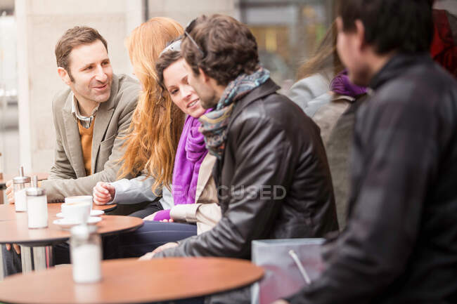Couples having coffee at sidewalk cafe — Stock Photo