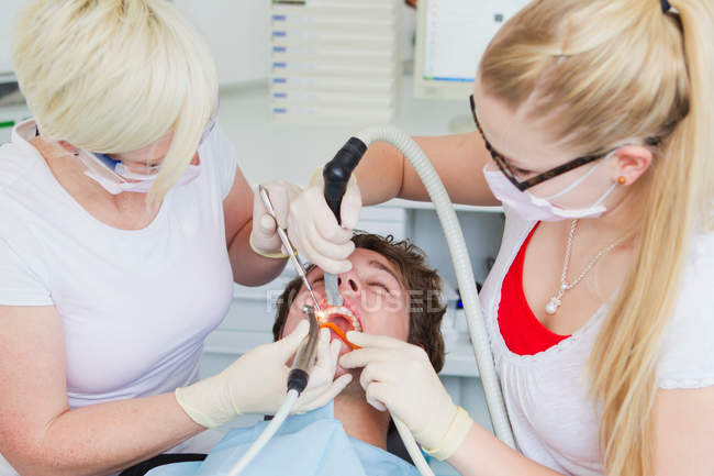 Dentistes travaillant sur les dents des patients — Photo de stock