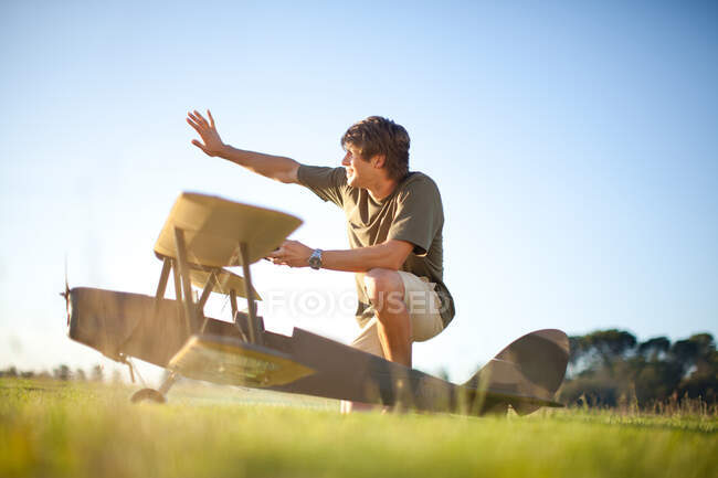 Homem brincando com avião de brinquedo no parque — Fotografia de Stock