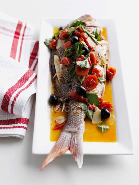 Рыба с помидорами и оливками — стоковое фото