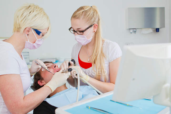 Dentists working on patients teeth — Stock Photo