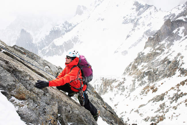 Mulher adulta média escalando na montanha — Fotografia de Stock