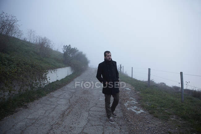 Uomo che cammina sulla strada rurale — Foto stock