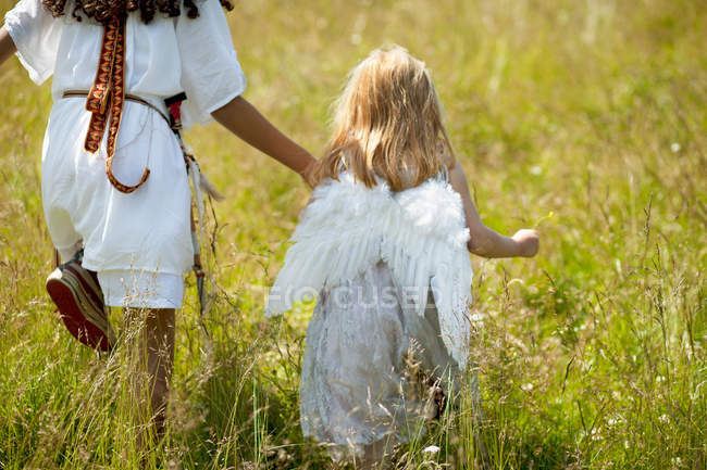 Girls in costumes walking in field — Stock Photo