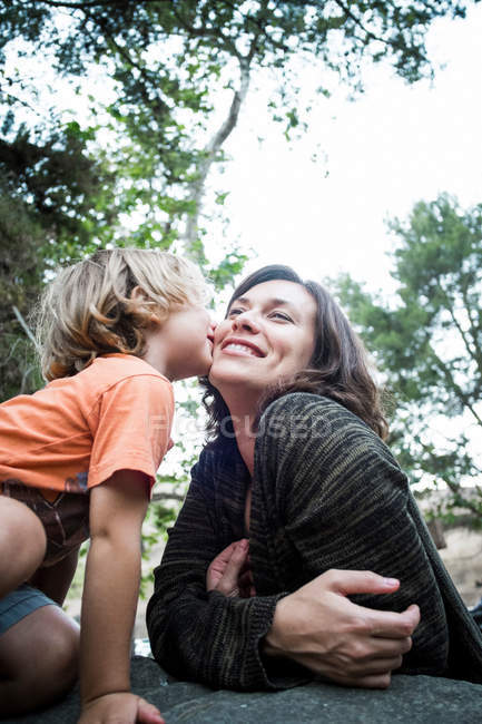 Son kissing mother in forest — Stock Photo