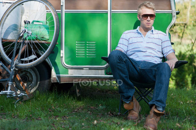 Человек, сидящий снаружи трейлера — стоковое фото